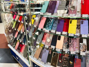 Kyiv, Ukraine - February 05, 2025: Variety of phone cases arranged inside a retail glass cabinet within a mall clipart