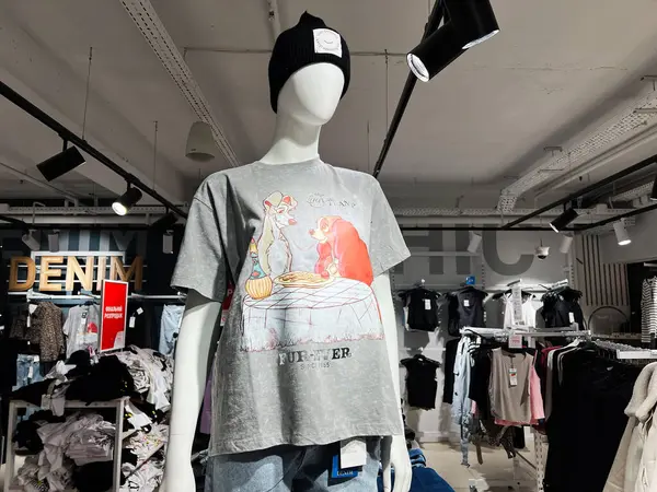 Kyiv, Ukrayna - 5 Şubat 2025: Modern bir giyim mağazasında şık bir grafik tişört ve bere sergileniyor