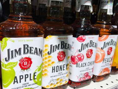 Kyiv, Ukrayna - 4 Şubat 2025: Çeşitli Jim Beam viski şişeleri elma ve siyah kiraz gibi eşsiz tatları sergiliyor.
