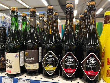 Kyiv, Ukrayna - Şubat 04, 2025: Bir süpermarket rafında düzgünce düzenlenmiş çeşitli şişe elma şarabı aromaları.