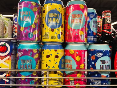 Kyiv, Ukrayna - Şubat 04, 2025: Çeşitli meyve aromalı Yummi Miami soda kutuları raflarda renkli bir düzende dizilmiş.