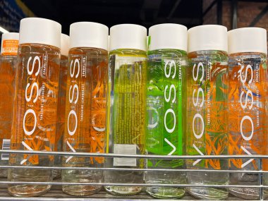 Kyiv, Ukraine - February 04, 2025: Selection of Voss sparkling water bottles, displayed on a store shelf, with vibrant colors. clipart