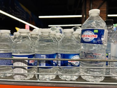 Kyiv, Ukrayna - Şubat 04, 2025: Parlak bir süpermarket ortamında düzgünce düzenlenmiş çeşitli kristal şişe su şişeleri.