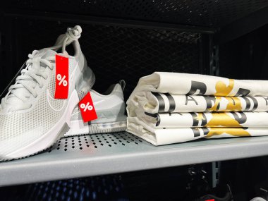 Kyiv, Ukrayna - 09 Şubat 2025: Running Nike Air Jordan spor ayakkabıları ve indirimli etiketli tişörtler bir mağazanın rafında sergileniyor.