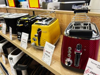 Kyiv, Ukrayna - 09 Şubat 2025: Renkli Delonghi tost makineleri mutfak gereçleri mağazasının ahşap rafında yerleştirildi