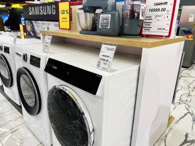 Kyiv, Ukraine - February 09, 2025: An electronics store showcases a variety of washing machines and kitchen appliances. clipart