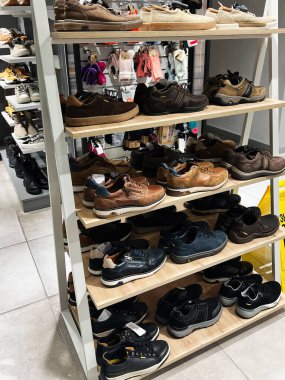 Kyiv, Ukrayna - 09 Şubat 2025: Çağdaş bir perakende ortamda raflarda gösterilen şık erkek ayakkabıları çeşitliliği.