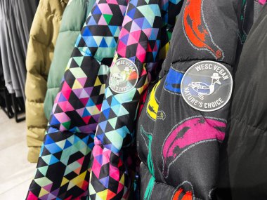 Kyiv, Ukrayna - 09 Şubat 2025: Renkli WeSC desenli ceketlerin yakın çekimi vegan etiket detaylarıyla raflarda sergilendi.