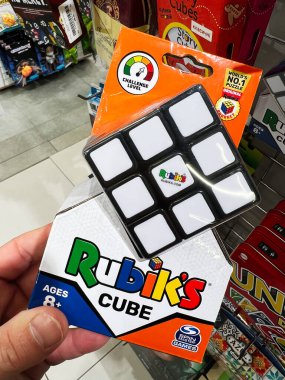 Kyiv, Ukrayna - 09 Şubat 2025: Rubik 'in küp kutusunu tutan, bir mağazada bulmaca oyuncağı rafı sergileyen.