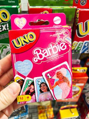 Kyiv, Ukraine - February 09, 2025: Colorful UNO card game featuring Barbie movie theme held in a retail store. clipart