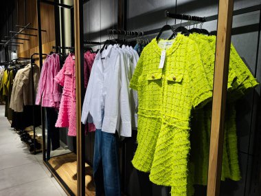 Kyiv, Ukrayna - 09 Şubat 2025: Şık görünümlü çağdaş bir butik iç mekanda canlı giysi ürünlerinin sergilenmesi