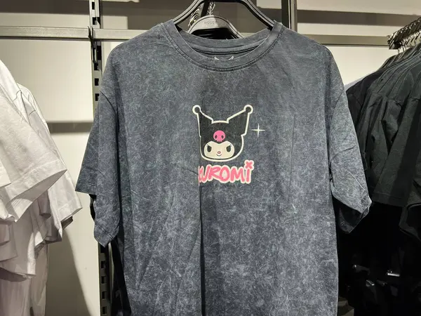 Kyiv, Ukrayna - 09 Şubat 2025: Kuromi karakteri grafikli koyu renkli gömlek, bir mağazada asılı askıda sunuldu