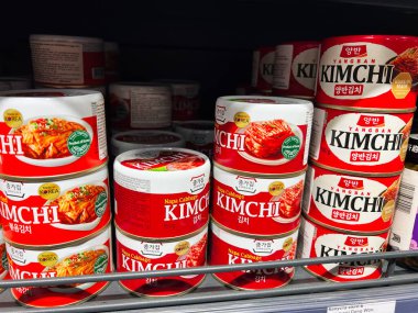 Kyiv, Ukraine - February 11, 2025: Variety of canned kimchi brands stacked on shelves emphasizing Korean cuisine clipart