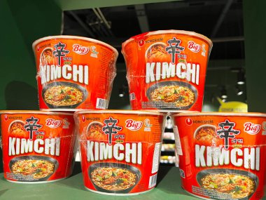 Kyiv, Ukrayna - 11 Şubat 2025: Bir mağazada parlak ışık altında yığılmış birden fazla Nongshim kase hazır kimchi eriştesi