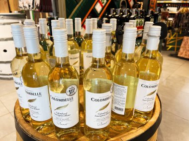 Kyiv, Ukrayna - 11 Şubat 2025: Kolombiya? Sauvignon Blanc şarap şişeleri iyi organize edilmiş bir mağaza ortamında bir fıçının üzerinde sergilenmektedir..