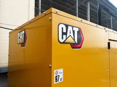 Lviv, Ukraine - February 12, 2025: Yellow industrial CAT equipment displayed outdoors, showcasing branding and specification details clipart