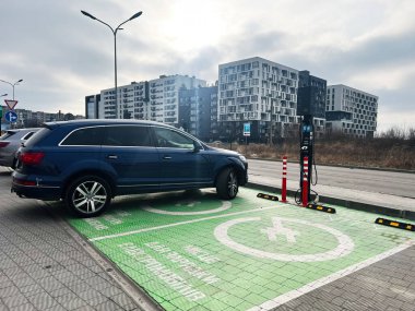 Lviv, Ukrayna - 12 Şubat 2025: Elektrikli araba halka açık bir şarj istasyonunda park edilmiş ve şarj ediliyor.