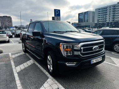 Lviv, Ukrayna - 12 Şubat 2025: Siyah bir Ford F 150 XLT kamyonet açık hava otoparkına park edilmiş şehir çevresi.