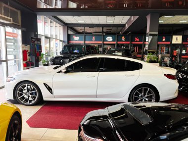 Lviv, Ukrayna - 12 Şubat 2025: Lüks beyaz BMW M850 araç galeride sergileniyor zarafet ve modernliğe odaklanıyor