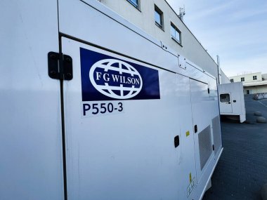 Lviv, Ukrayna - 12 Şubat 2025: Çağdaş bir binanın yakınında bulunan büyük bir FG Wilson P 550-3 endüstriyel güç jeneratörü.