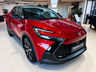 Lviv, Ukrayna - 12 Şubat 2025: Toyota C-HR canlı kırmızı ile zarif, çağdaş bir bayilik ortamında sergilendi.