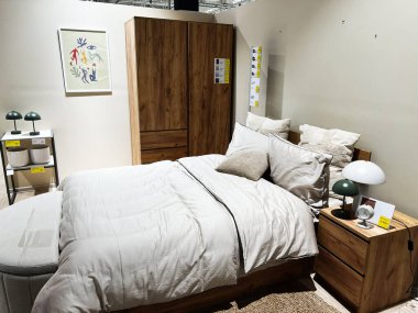 Lviv, Ukrayna - 13 Şubat 2025: Ahşap döşemelerin, yumuşak döşemelerin ve minimalist dekorun yer aldığı parlak ve rahat yatak odası