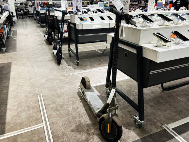 Lviv, Ukrayna - 13 Şubat 2025: Modern bir elektronik mağazasında elektrikli scooter ve akıllı telefon seçimi