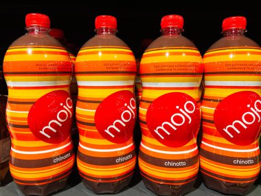 Lviv, Ukrayna - 13 Şubat 2025: Parlak çizgili dizaynlarla sıralanmış renkli MOJO chinotto şişeleri