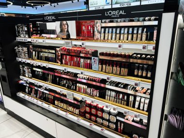 Lviv, Ukrayna - 13 Şubat 2025: Loreal Paris 'in çeşitli kozmetik ürünleri ve makyaj ürünleri aydınlatılmış bir mağazada raflarda sergileniyor.