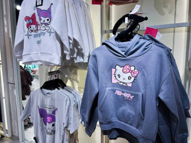 Lviv, Ukrayna - 13 Şubat 2025: Sevimli renkli karakter çizimlerinin yer aldığı çeşitli ticari kapüşon ve tişörtler