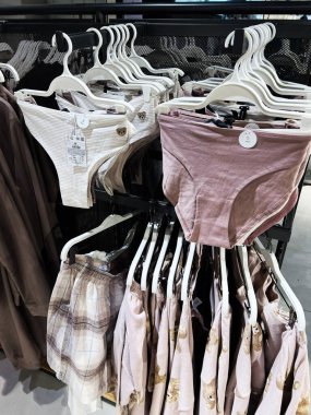 Lviv, Ukrayna - 13 Şubat 2025: Yumuşak kumaş iç çamaşırı ve mağazada satılık askılarda sergilenen günlük kıyafetler