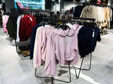 Lviv, Ukrayna - 13 Şubat 2025: Pembe ve denizci kapüşonlular şık bir perakende mağazasında raflarda sergileniyor