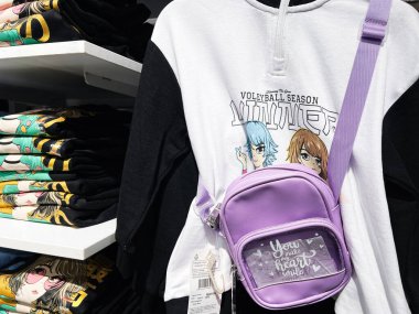 Lviv, Ukrayna - 13 Şubat 2025: Anime 'de eşofman altı, mor mini çanta ve katlanmış grafik tişörtler