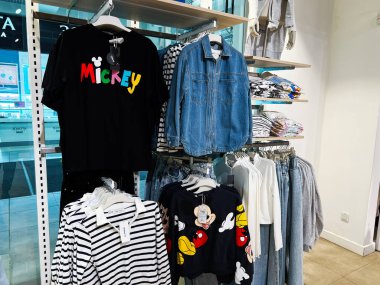 Lviv, Ukrayna - 13 Şubat 2025: Renkli markalı kıyafetler ve kot bir moda mağaza ortamında raflarda sergilendi