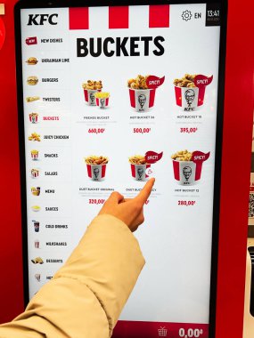 Lviv, Ukrayna - 13 Şubat 2025: Müşteri çeşitli seçenekleri olan dijital fast food menüsünden KFC ögeleri seçiyor