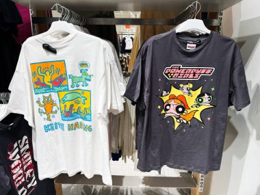 Lviv, Ukrayna - 13 Şubat 2025: Sanatsal ve karikatür tasarımlı iki moda tişört elbise rafında sergilendi