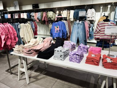 Lviv, Ukrayna - 16 Şubat 2025: Renkli katlanmış giyim ve kotlar perakende satış masalarında düzgünce sergilendi