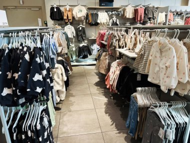 Lviv, Ukrayna - 16 Şubat 2025: Renkli ve şık çocuk kıyafetleri bir perakende mağazasının içinde düzgünce dizilmiş.