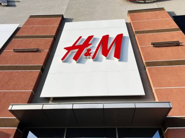 Lviv, Ukrayna - 16 Şubat 2025: Kırmızı renkli H ve M logosu kahverengi binanın dış cephesine monte edilmiş beyaz panel.