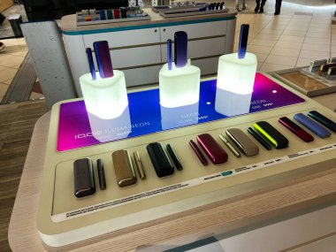 Lviv, Ukrayna - 16 Şubat 2025: Iqos elektronik sigara içme cihazları ve renkli aksesuarlar üst düzey bir perakende mağazasında sergilendi.