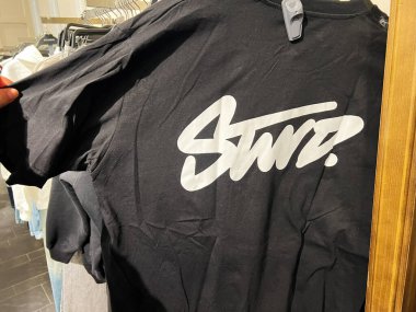 Lviv, Ukrayna - 16 Şubat 2025: Bir perakende askısında STWD logosu sergilenen şık siyah bir tişörtün yakın çekimi