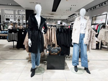 Lviv, Ukrayna - 16 Şubat 2025: Mankenler giyim eşyalarıyla çevrili perakende mağazasında moda kış kıyafetlerini sergiliyorlar.