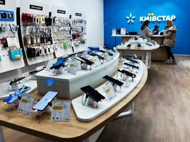 Lviv, Ukrayna - 16 Şubat 2025: Akıllı telefon ve aksesuarların yer aldığı Kyivstar perakende mağazası, müşterilerin gezindiği ve etkileşimde olduğu ürünleri sergiliyor.
