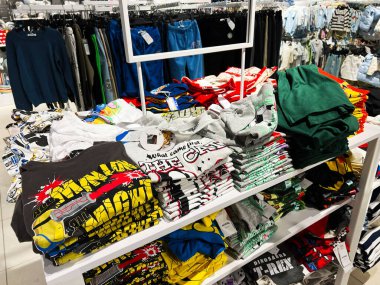 Lviv, Ukrayna - 16 Şubat 2025: Bir çocuk moda mağazasında sergilenen canlı grafik tişört yığınları