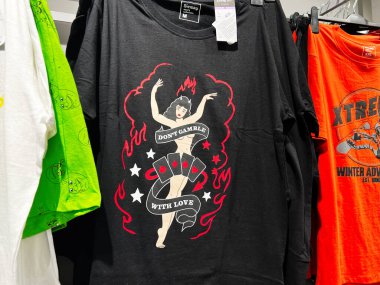 Lviv, Ukrayna - 16 Şubat 2025: Aşkla kumar oynama. Geçmişe dönük kumar temalı bir tasarımı sergileyen şık siyah bir tişört.