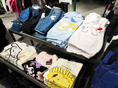 Lviv, Ukrayna - 16 Şubat 2025: Karakter temalı tasarımların yer aldığı istiflenmiş giyim ürünleri, perakende raflarında düzgünce organize edildi.