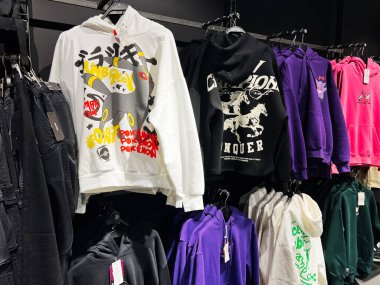 Lviv, Ukrayna - 16 Şubat 2025: Canlı bir perakende ortamında askıda asılı çeşitli grafik kapüşonlular