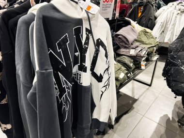 Lviv, Ukrayna - 16 Şubat 2025: NYC perakende mağaza ortamında elbise raflarında sergilenen kapüşonlu sweatshirtler.