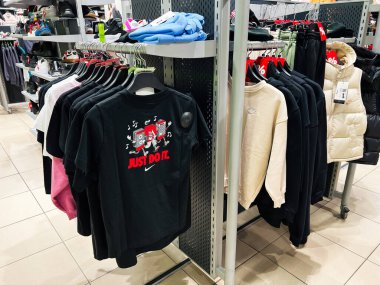 Lviv, Ukrayna - 16 Şubat 2025: Nike 'ın müşteriler için düzgün bir şekilde düzenlenmiş askılar ve raflar üzerinde spor giysileri sergilediği bir perakende mağazası.