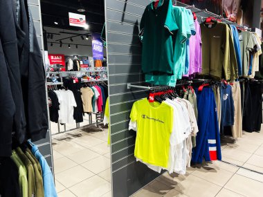 Lviv, Ukrayna - 16 Şubat 2025: Parlak ve modern dekoru olan bir mağaza ortamında moda giysileri sergileniyor